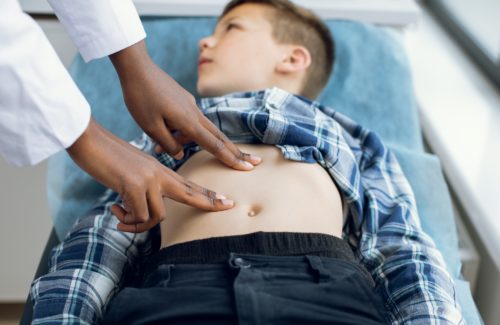 Child physical examination concept. Unrecognizable African American doctor performing manual